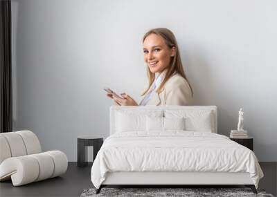 Portrait of young business woman using mobile phone isolated on white background Wall mural